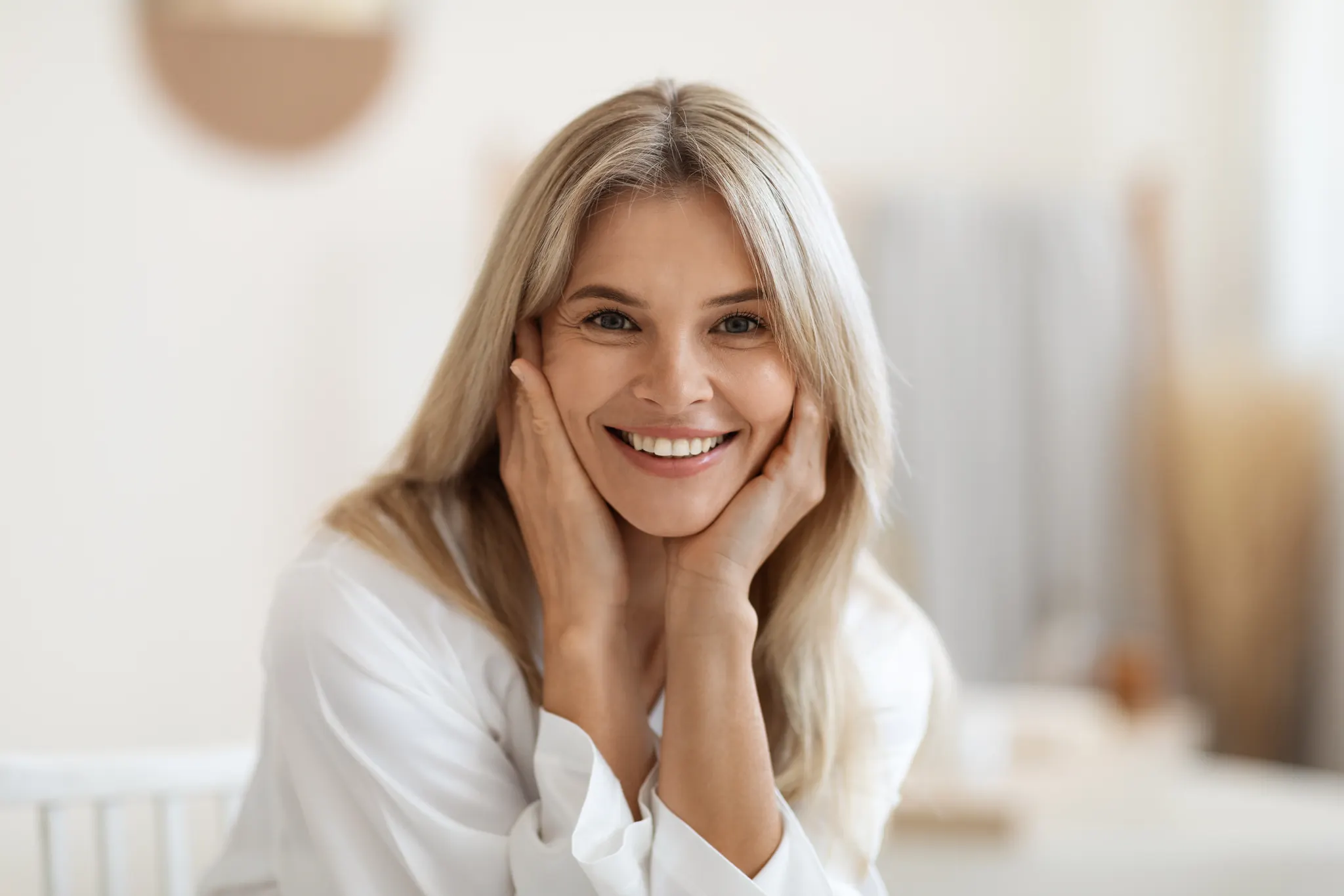 Smiling woman resting her face in her hands